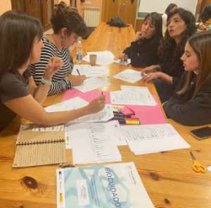 Un grupo de personas trabajando alrededor de una mesa con papeles