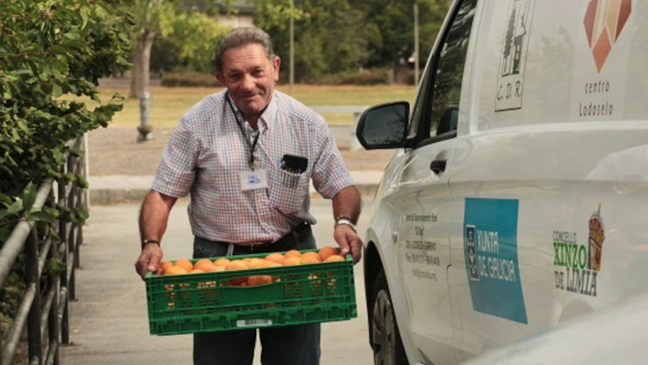 Un hombre transporta una caja de fruta