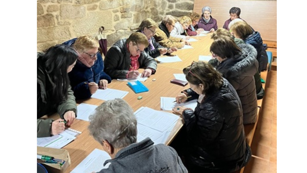 Un grupo de personas sentadas alrededor de una mesa escribiendo