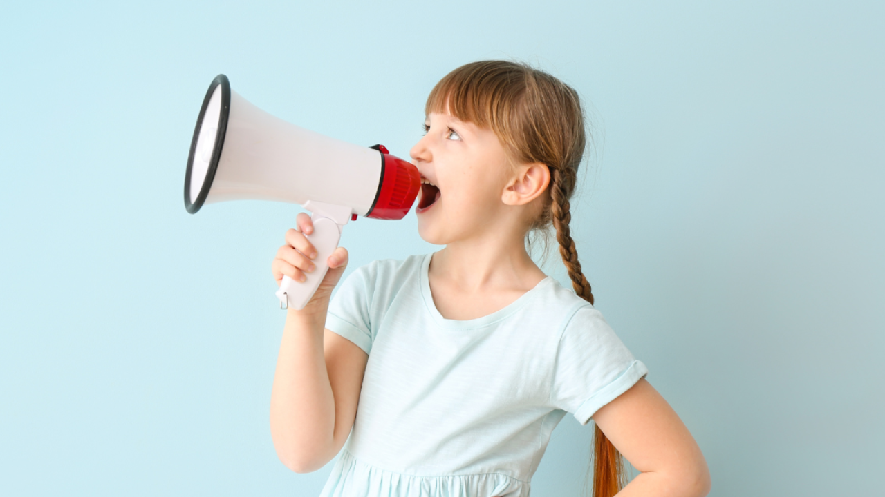 Una niña hablando con un megáfono en la mano