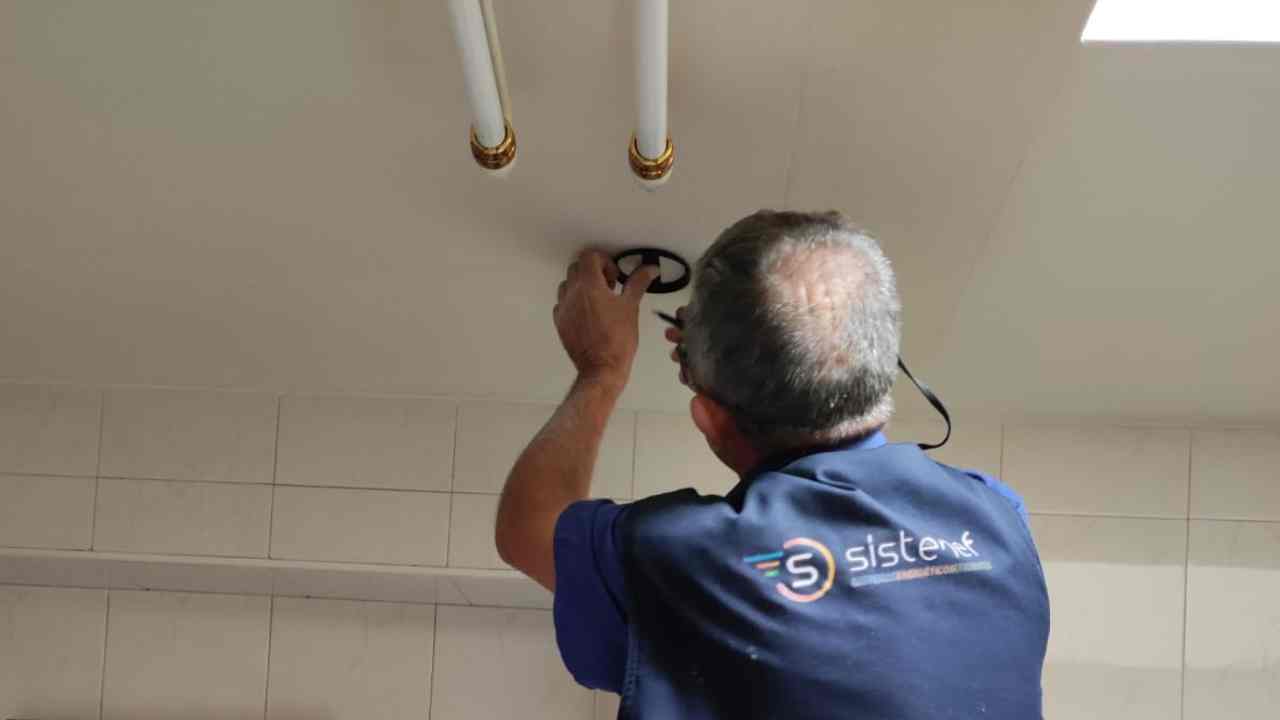 un señor de espaldas arreglando el techo de una vivienda