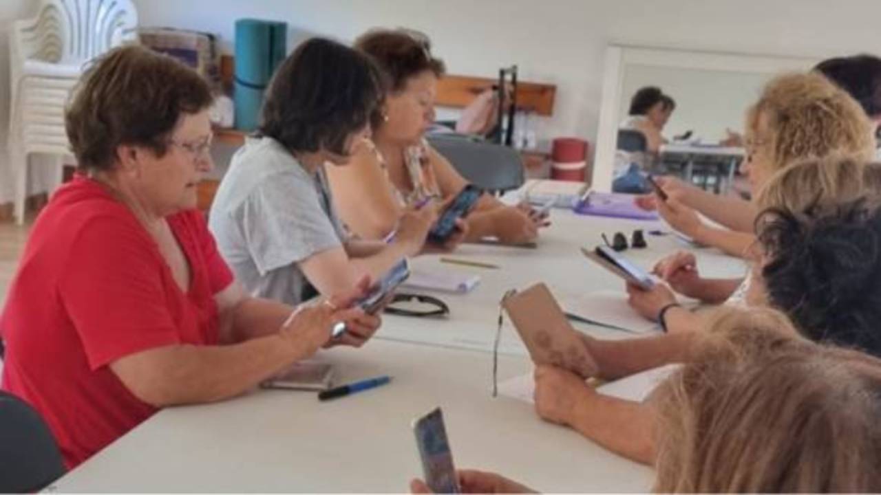 Grupo de mujeres con móvil aprendiendo el manejo de aplicaciones