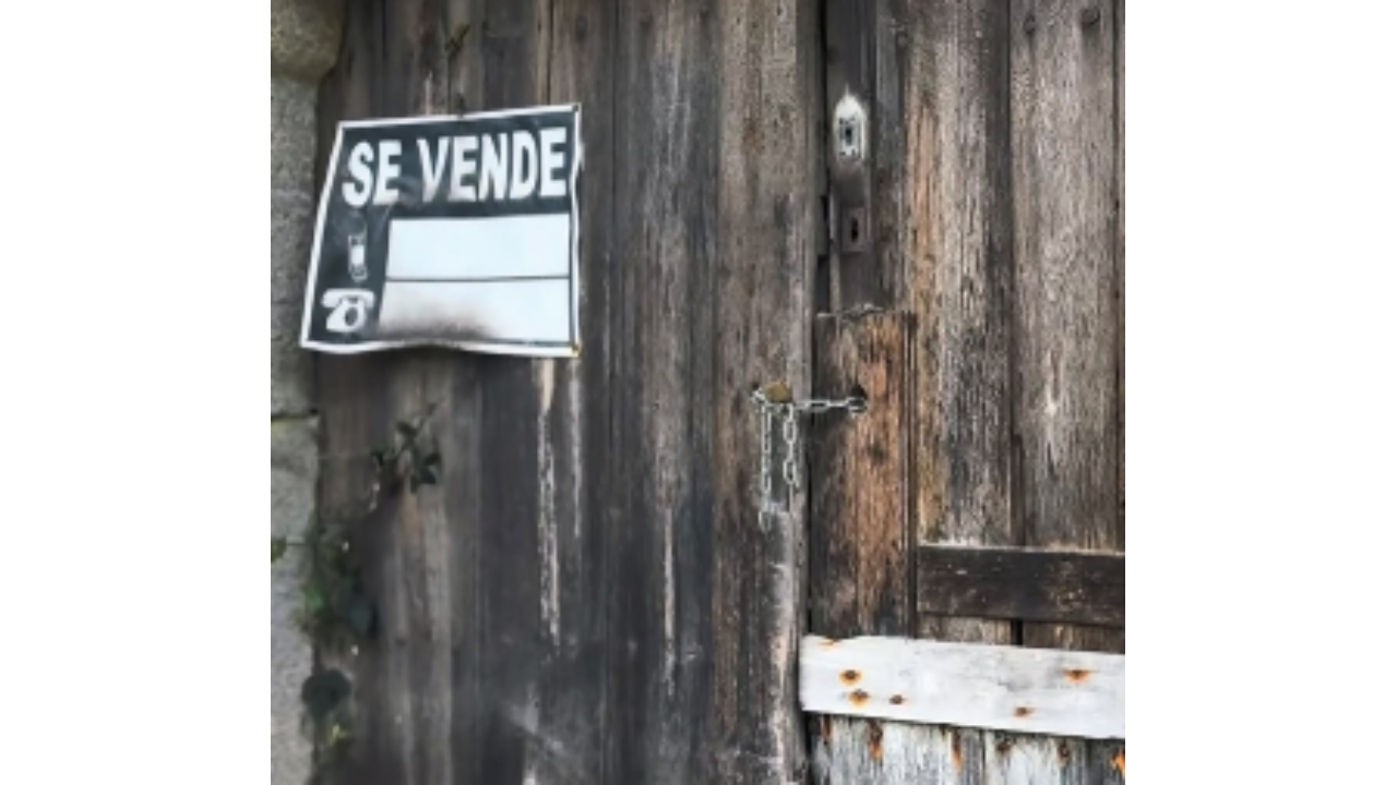 Cartel de "se vende" en la puerta de una casa 