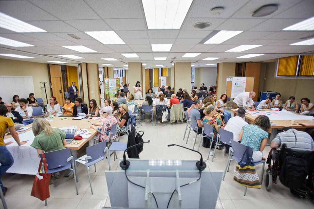 grupos de personas trabajando sentadas en distintas mesas