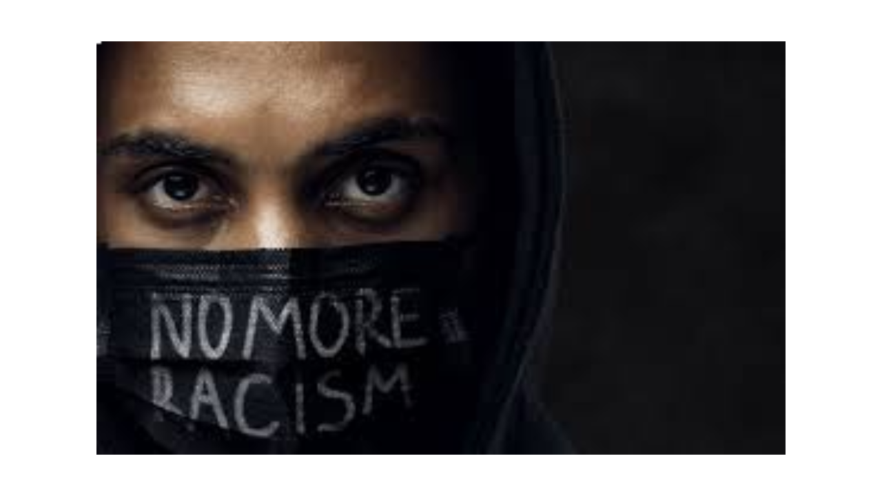Unos ojos de una persona con un cartel que pone no more racism