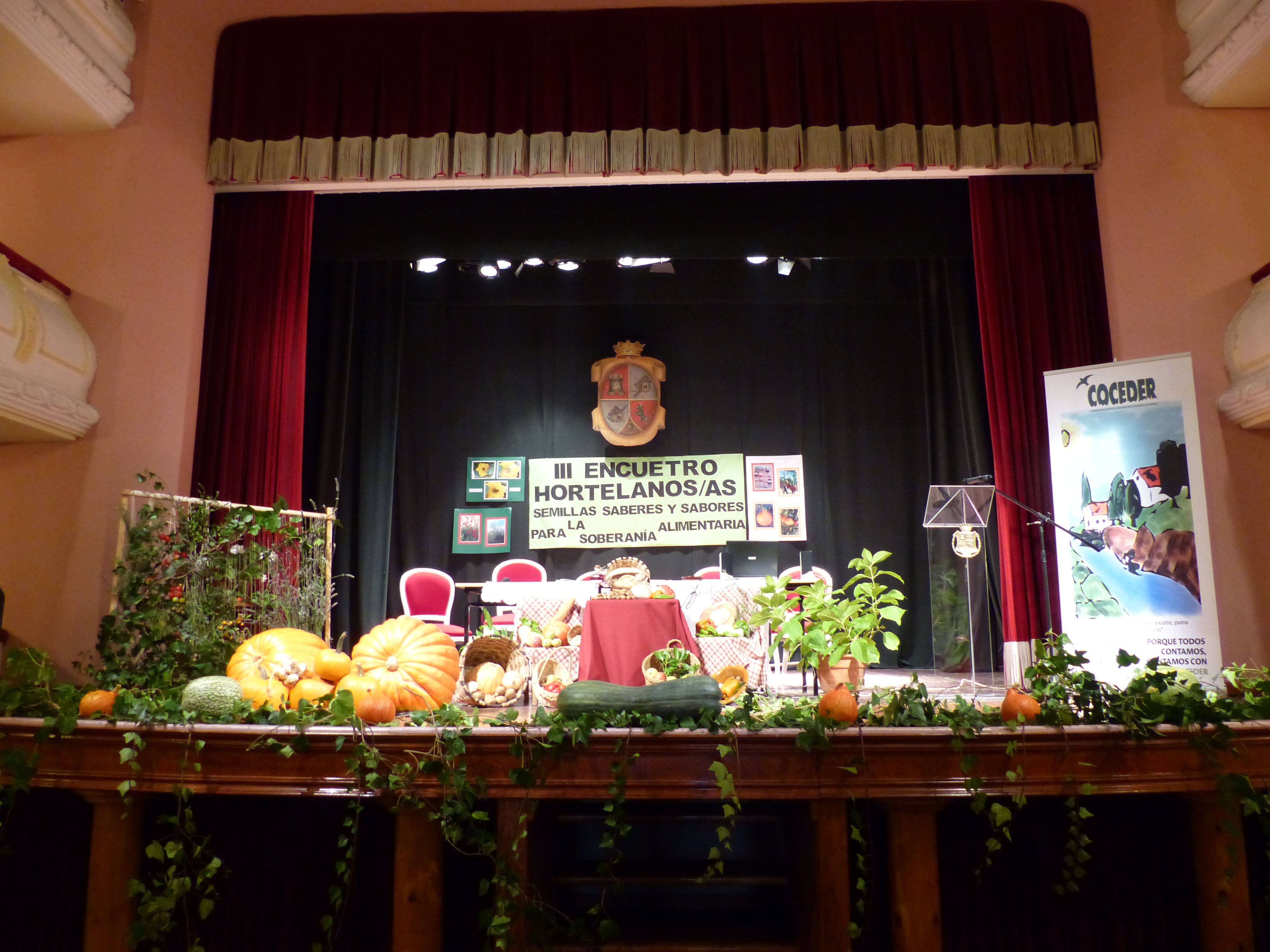 Escenario de un salón de actos lleno de productos de huertas