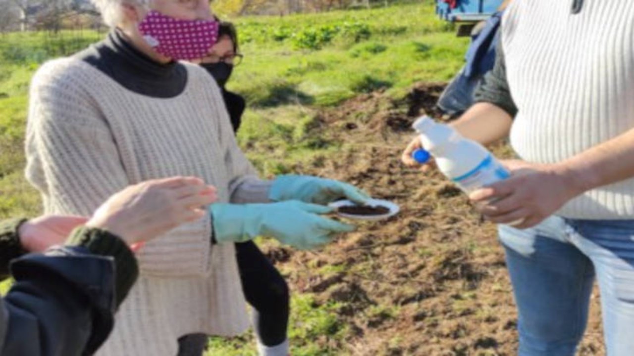 Persona con guantes y mascarilla recogiendo un liquido