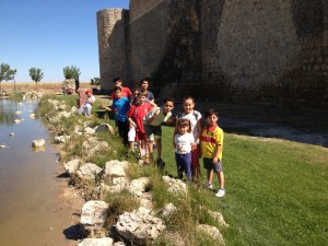 Grupo de niños a la orilla de un riachuelo con muy poco caudal de agua