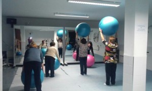 Grupo de mujeres mayores realizando actividades con una pelotas azules
