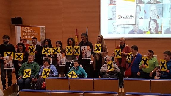 Grupo de personas sosteniendo una X solidaria 
