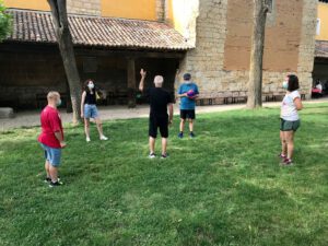 grupo de personas en circulo realizando un juego con un balón