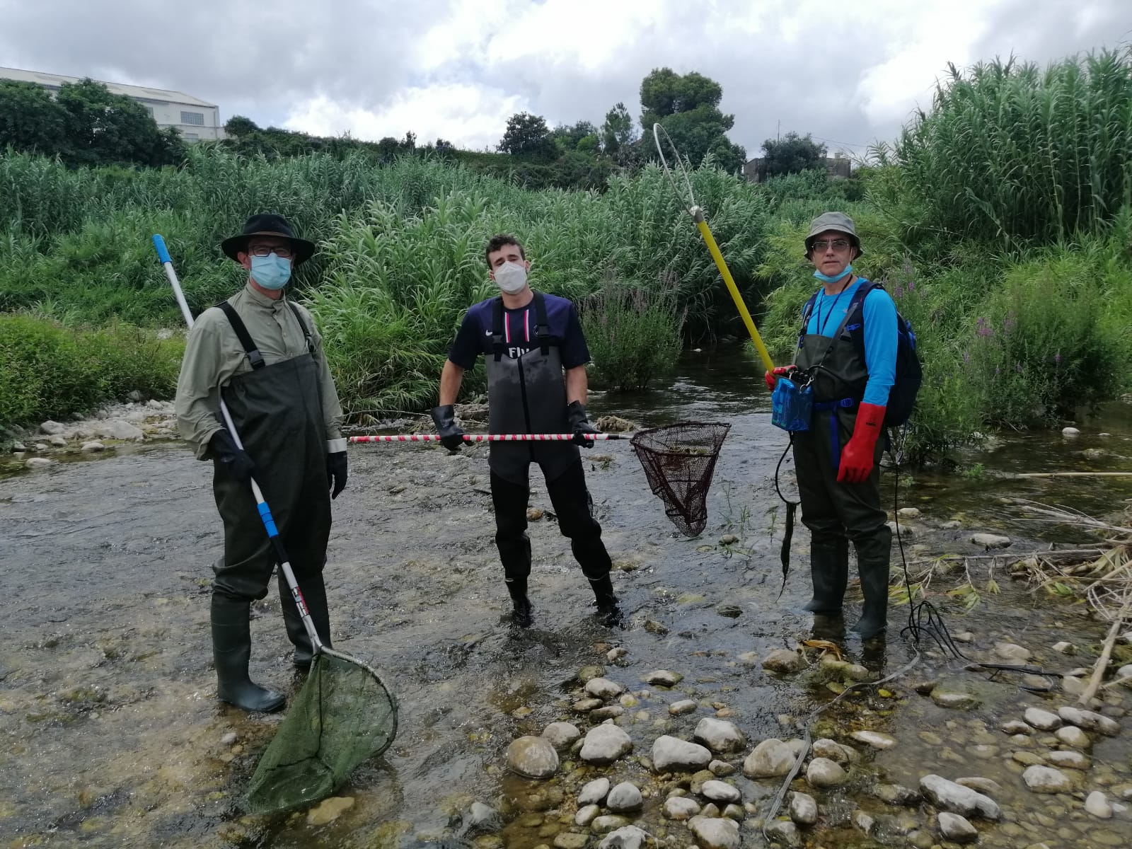 Tres señores con redes de pesca en un rio