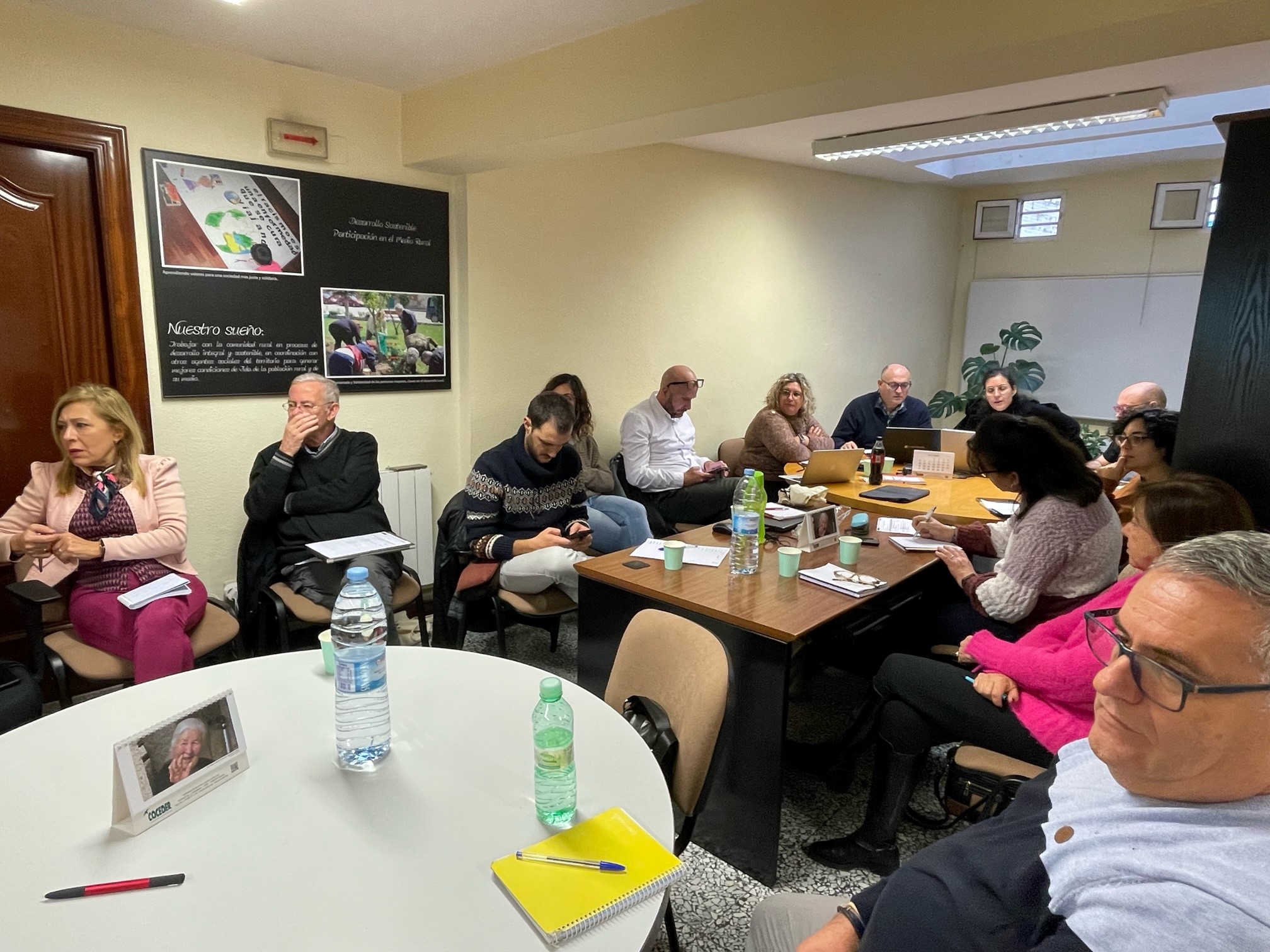 Reunión de personas de la entidad alrededor de mesas atendiendo al curso de gestión de entidades