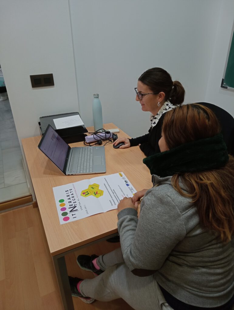 Dos mujeres mirando a un ordenador portátil, una de ellas manejando un ratón