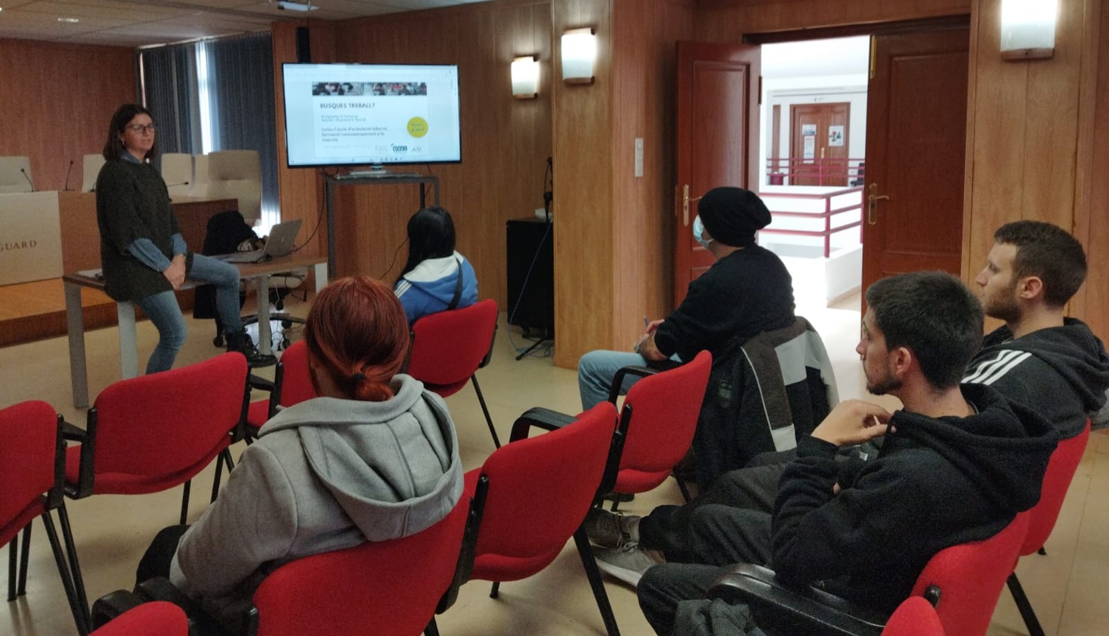 Grupo de personas jóvenes sentados en un salón atendiendo a la formación