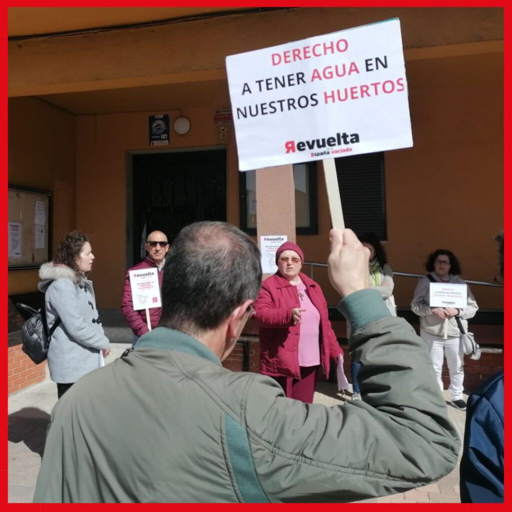 Grupo de personas en la calle mostrando pequeñas pancartas de la España vaciada