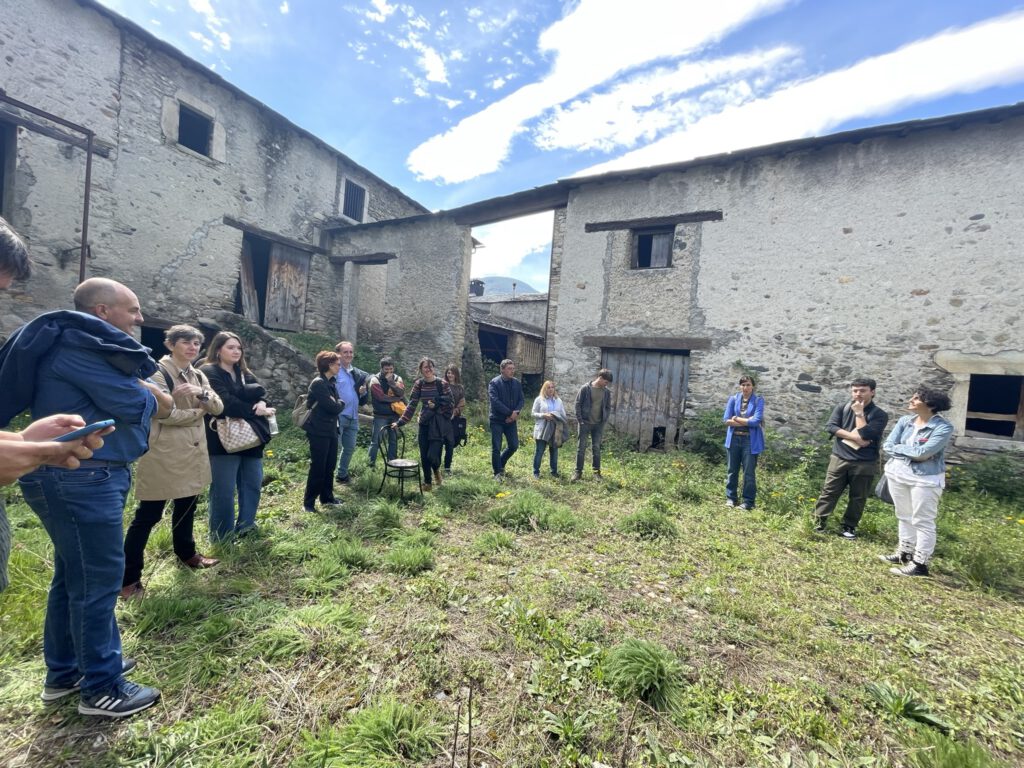 Grupo de personas en una zona rural, entre casas y suelo verde