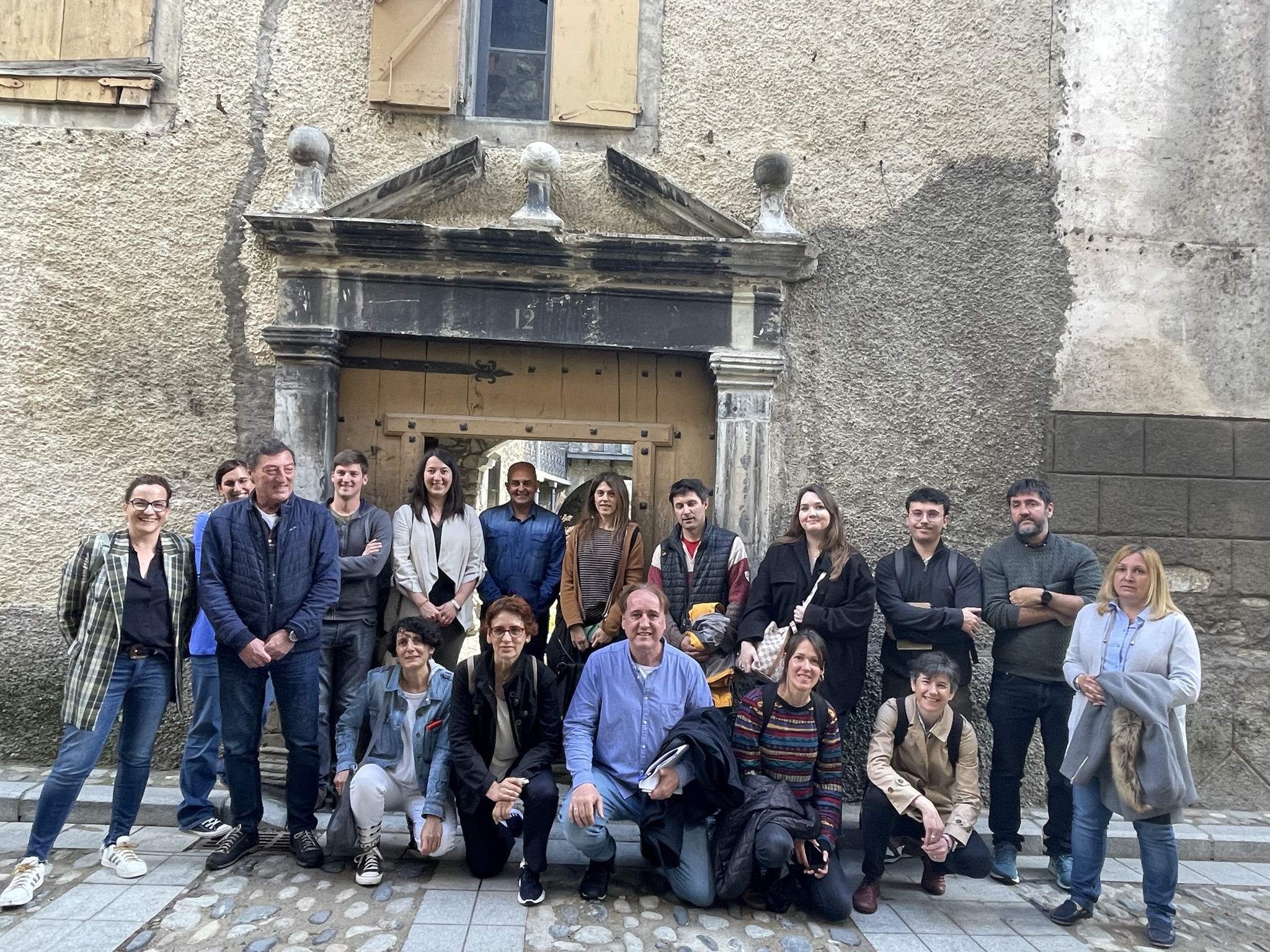 Grupo de personas del  Ministerio de Derechos Sociales y Agenda 2030 posando en una fachada de Benasque 