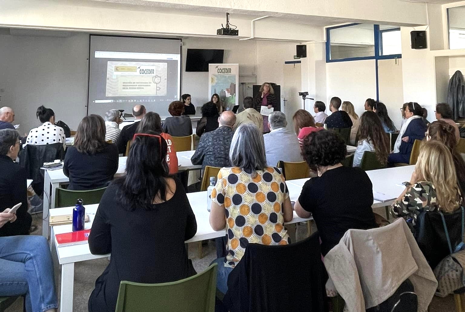 Aula con personas de espalda escuchando el curso gestión de entidades de desarrollo sostenible en el medio rural