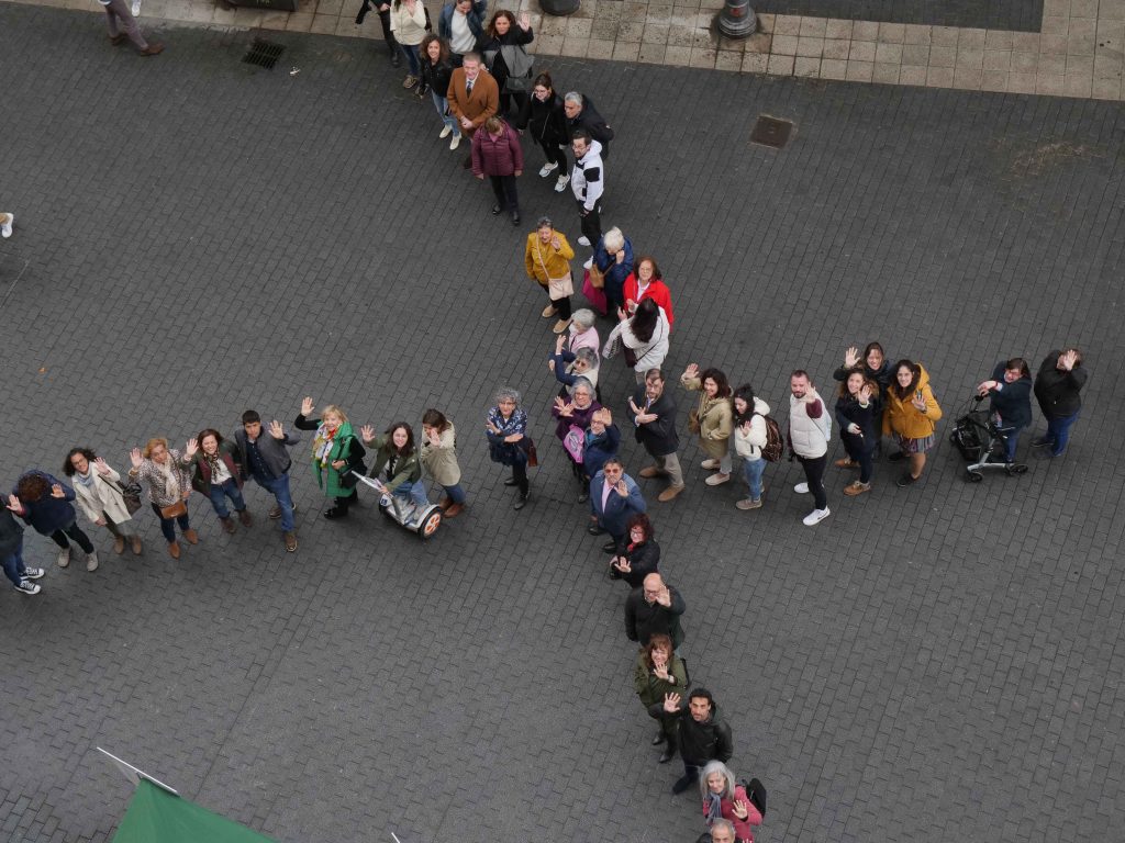 Imagen de personas formando una X en la calle